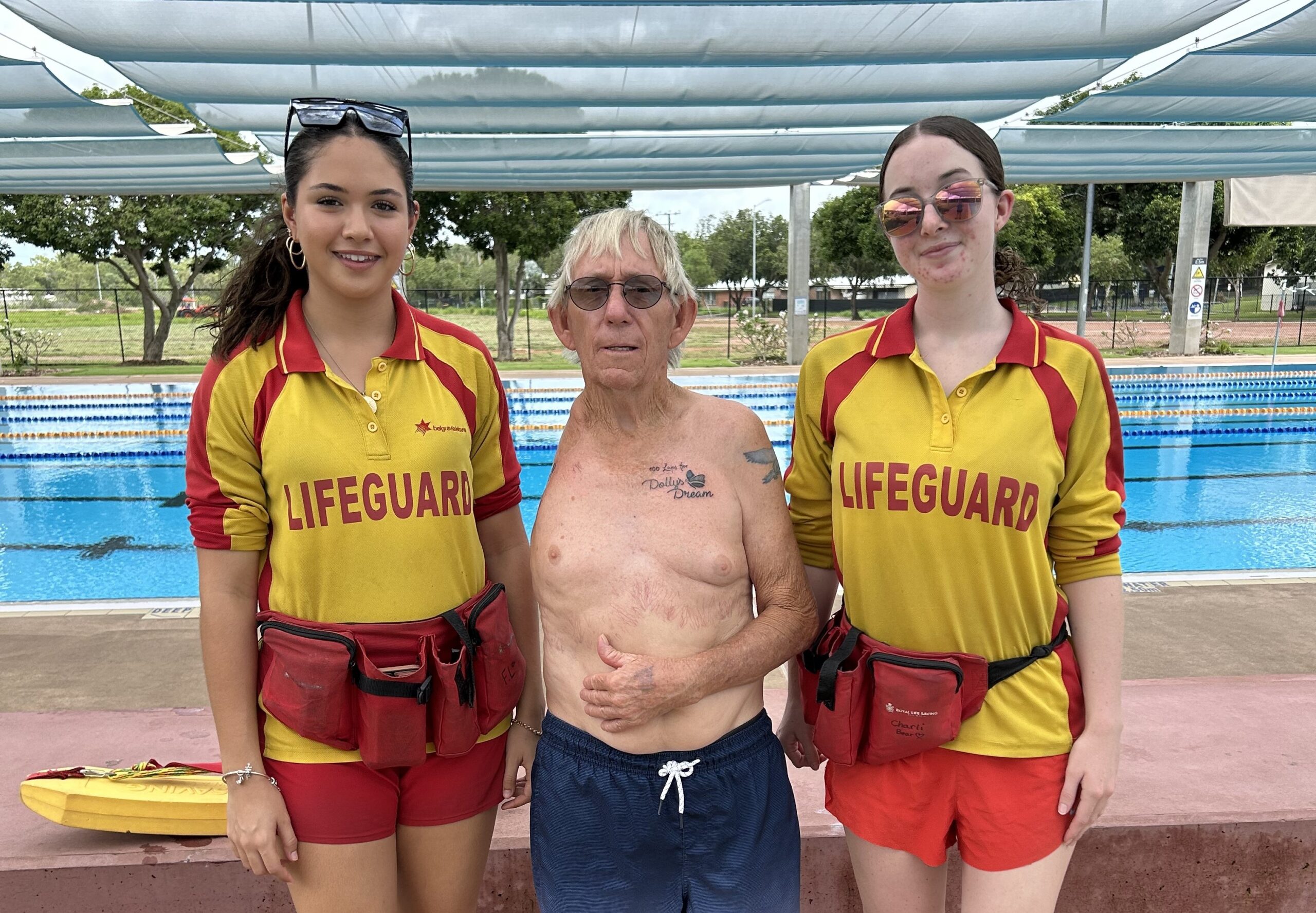 Image of 2 lifeguards and Gary, standing in front of the pool at Swell.